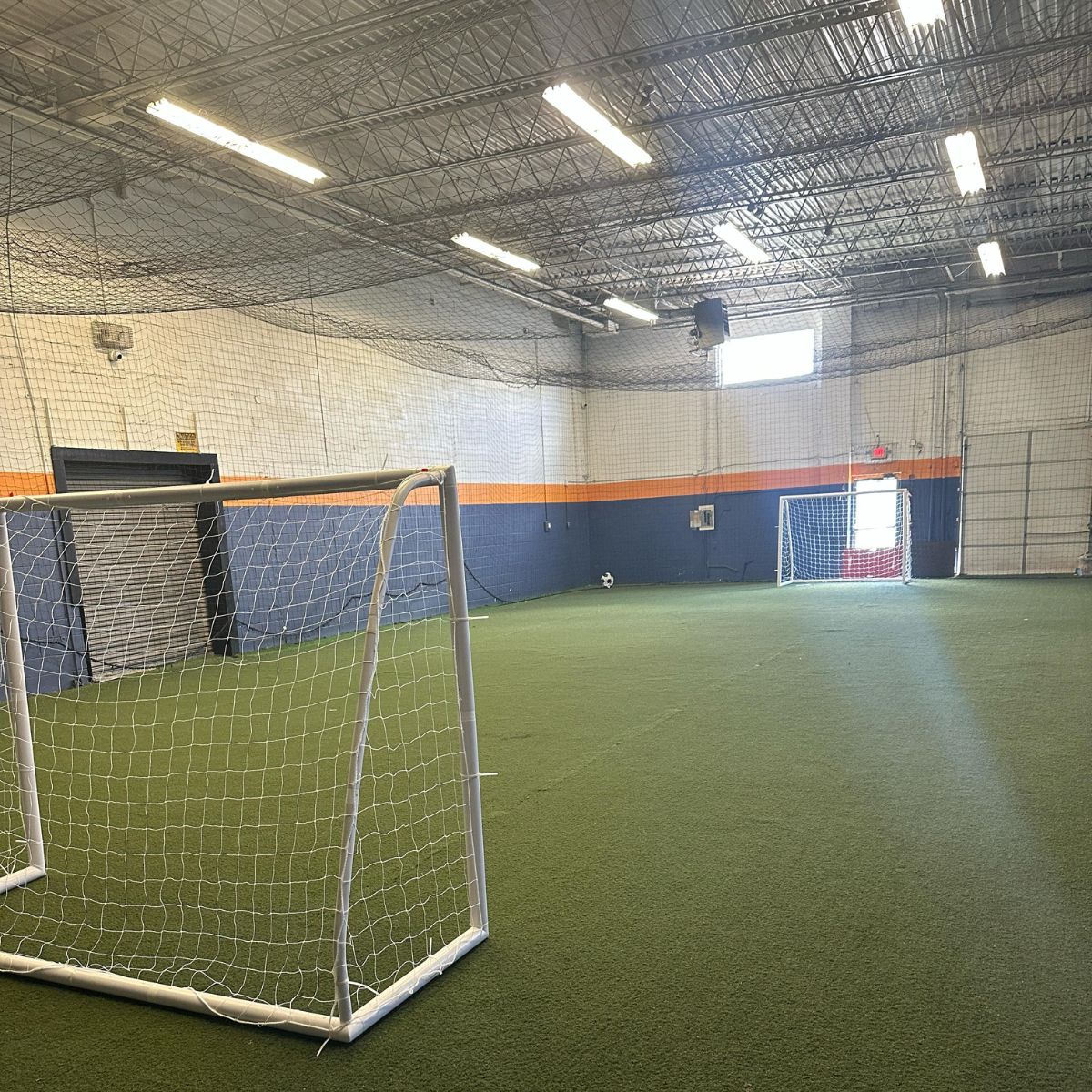 Total Soccer Indoor sports facility with soccer goal and artificial turf