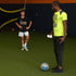Total Soccer trainer and kid on a sports field with a soccer ball, one wearing a TSX shirt and the other in a bright yellow shirt.