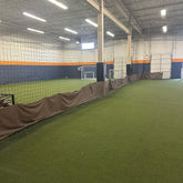 Total Soccer Indoor sports facility with green artificial turf and netting on the walls.