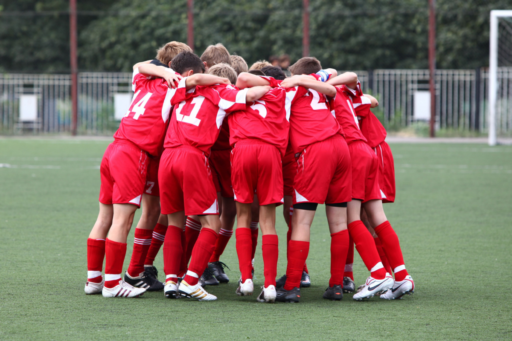 team of youth soccer players huddled together on the field